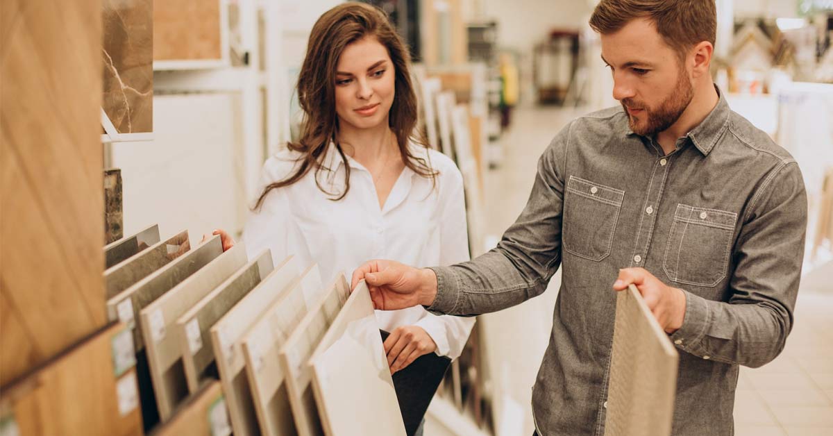 A beautiful white woman and men are choosing ceramic tiles.