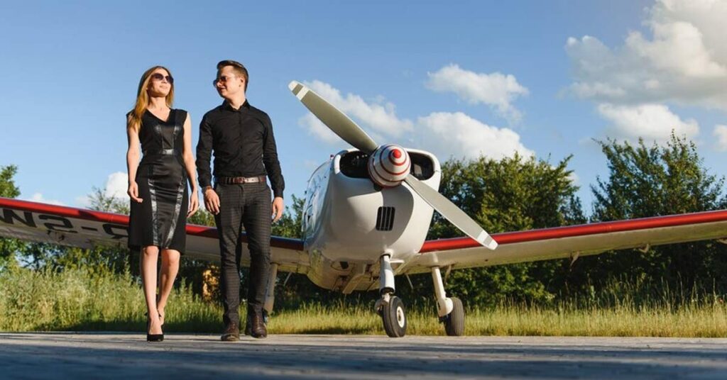 A white couple walking in front of their private plane