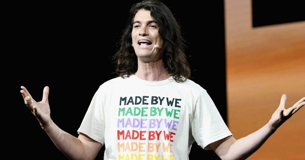 A picture of ex WeWork CEO Adam Neumann on-stage in a white T-shirt