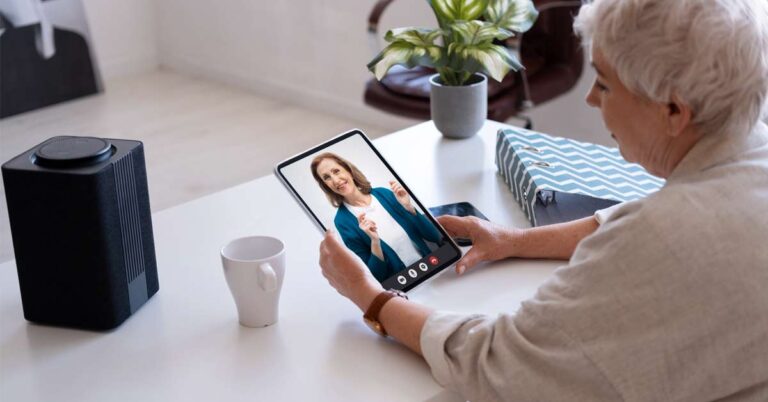 An elderly women taking video consultation with her female doctor over a tablet device.