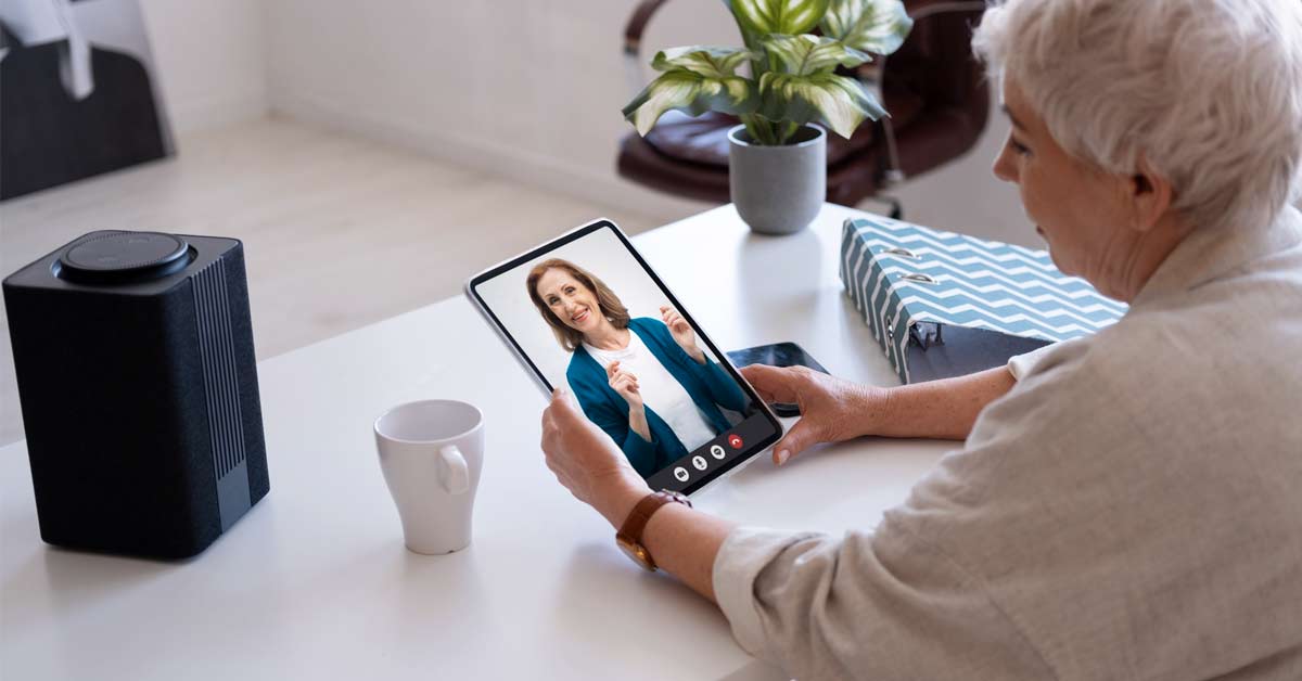 An elderly women taking video consultation with her female doctor over a tablet device.