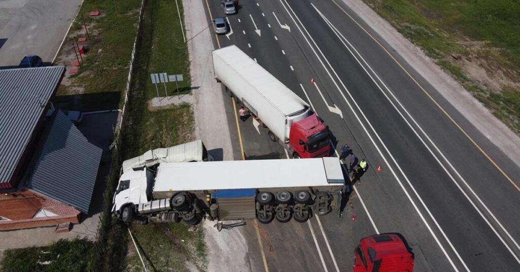 An aerial view of two trucks colliding on a highway.