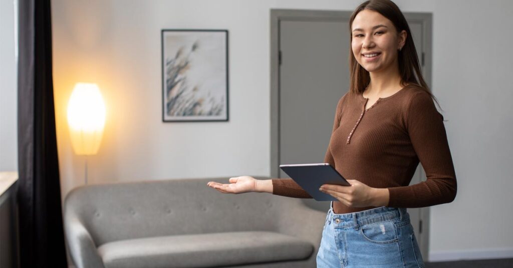 A beautiful woman in brown henley top showcasing a room with sofa