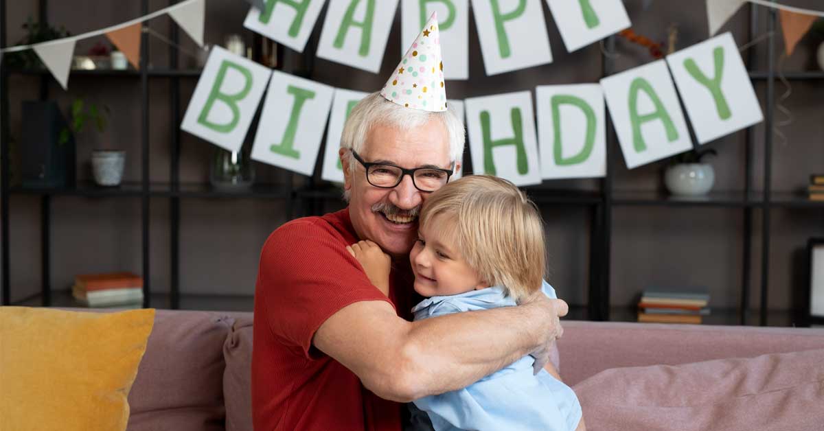 A 60 year old man hugging his grandson.