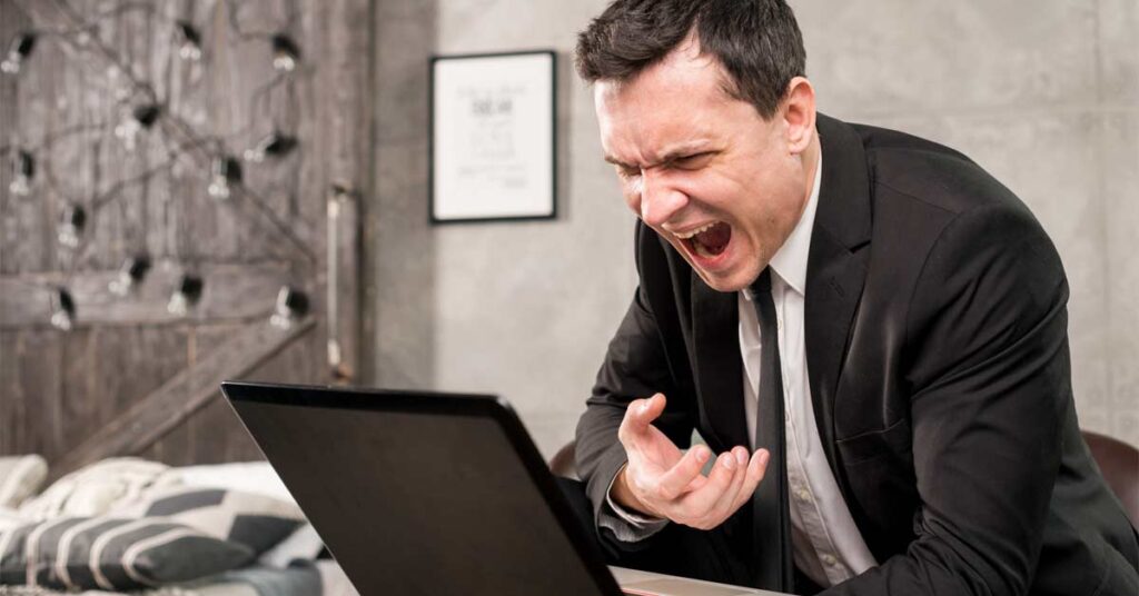 Angry businessman on an online meeting on a laptop