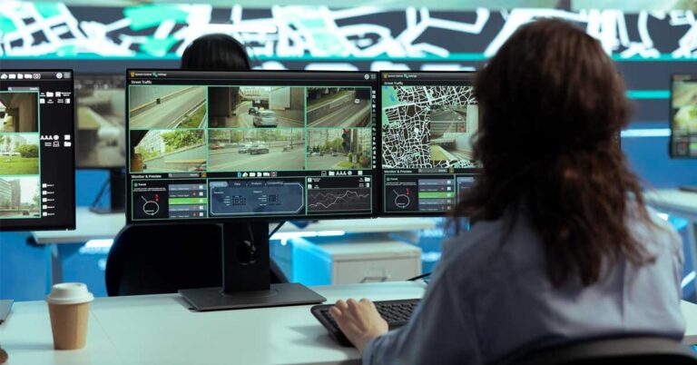 A women employee checking the cctv camera footage on multiple desktops