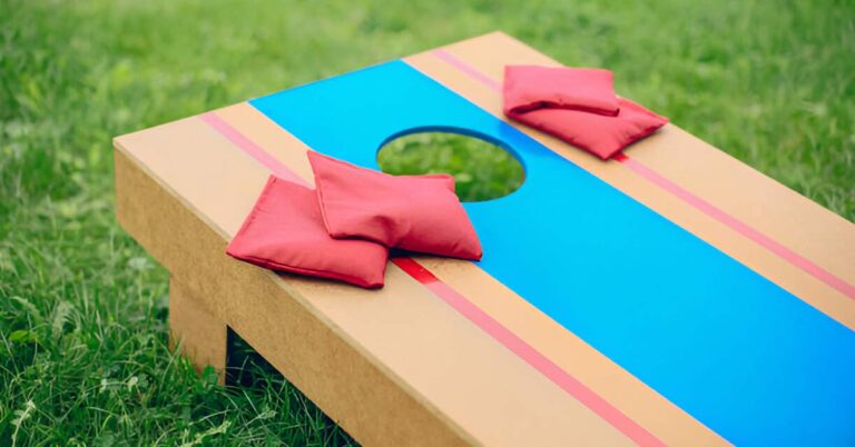 A cornhole board with 4 red colored cornhole bags