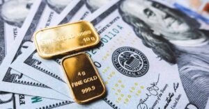 A couple of gold biscuits kept on $100 usd currency notes