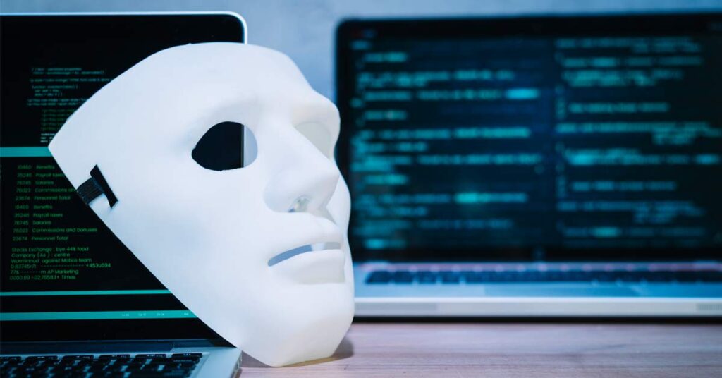 A hacker mask kept in front of a laptop device