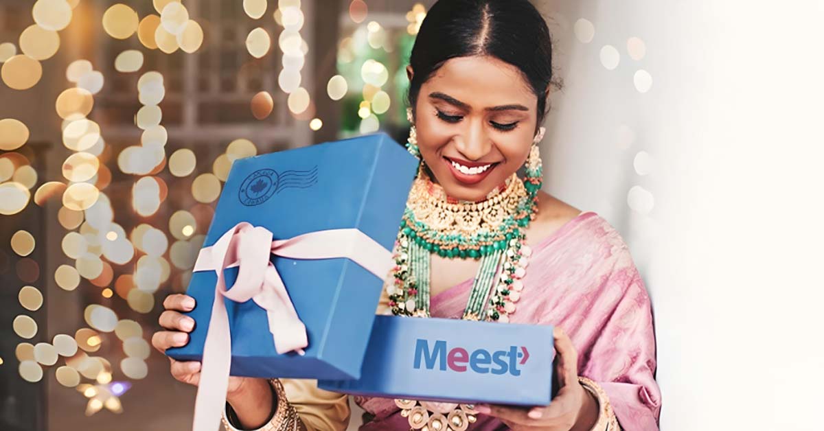 An Indian woman in a saree holding a parcelt box