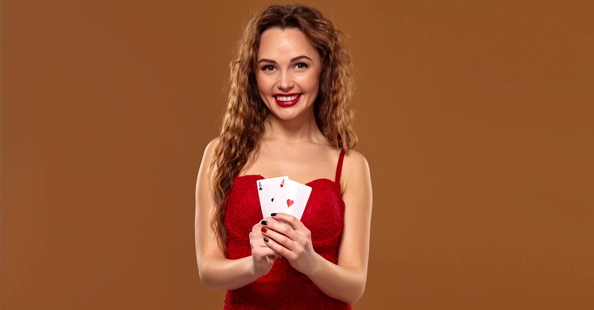 A beautiful woman in red dress holding playing cards