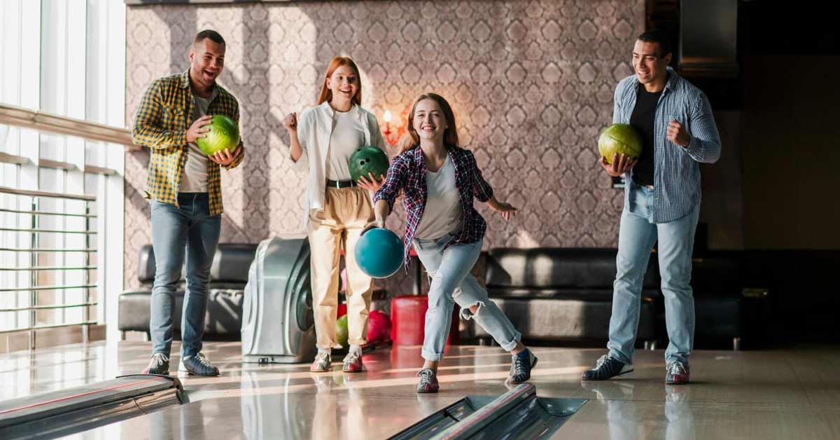 A group pf 4 youngsters playing a bowling match