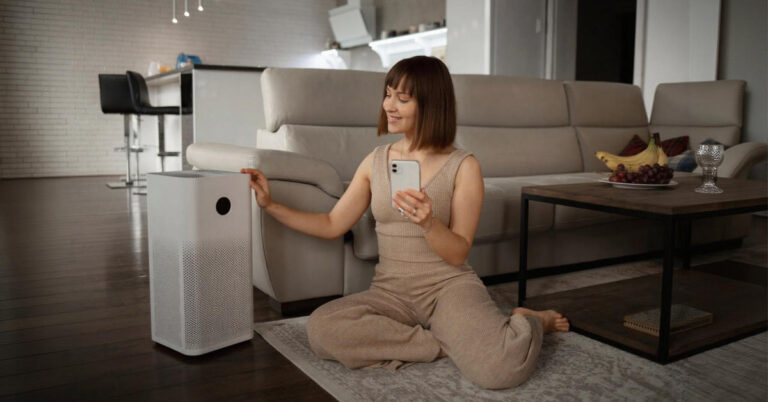 A beautiful white women sitting and operating her air purifier