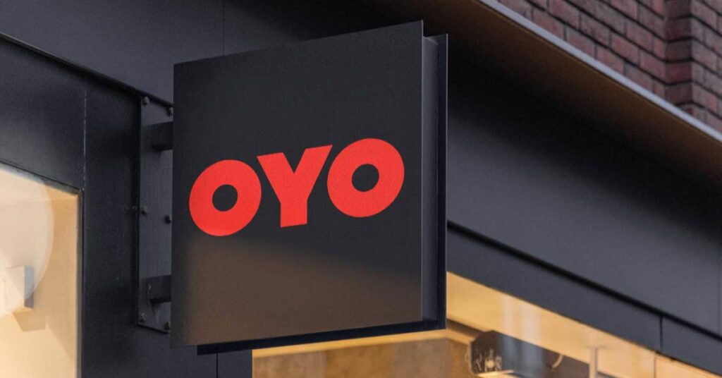 An OYO hoarding in front of a hotel gate.