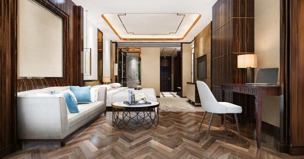 A lusturous home drawing room interior with White sofas, vitrified tile flooring and wooden structures.