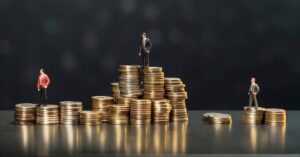 A picture showing miniature businessman dummies standing on stacks of coins - a business finance illustration