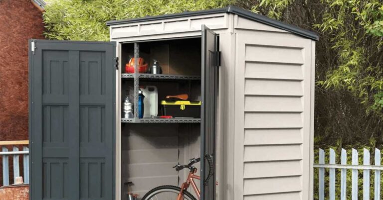 A vinyl shed in backyard with tools and a bicycle.