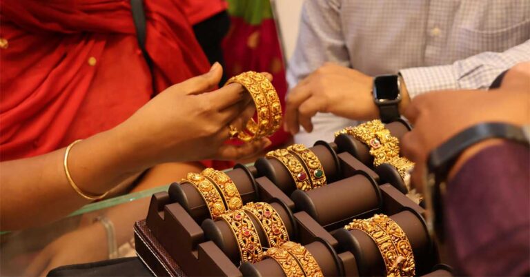 Picture depicting hands of a couple of Indian people - one female and other male holding gold bangles