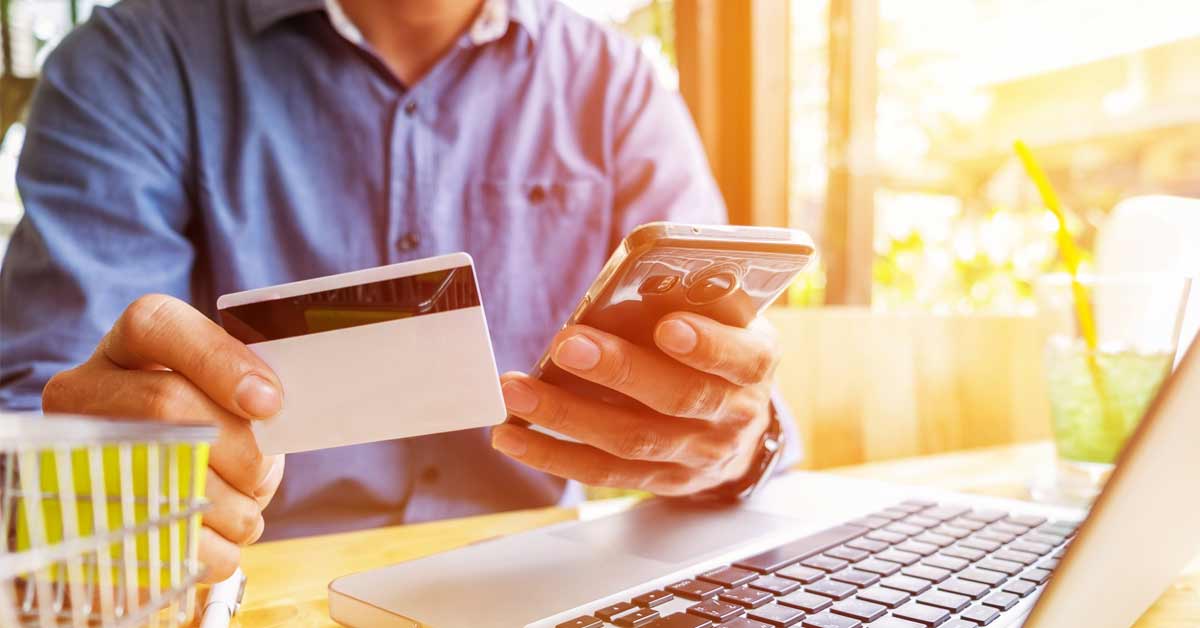 A person holding a credit card and smartphone - depicting a digital payment concept.