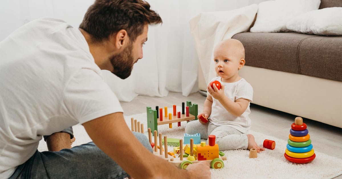 Father teaching his baby to play with toys - depicting a modern parenting concept