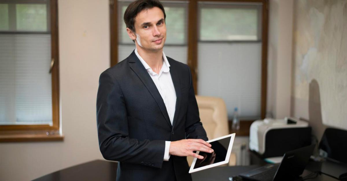 A male hotel manager operating on a talet device - depicting a hotel security concept