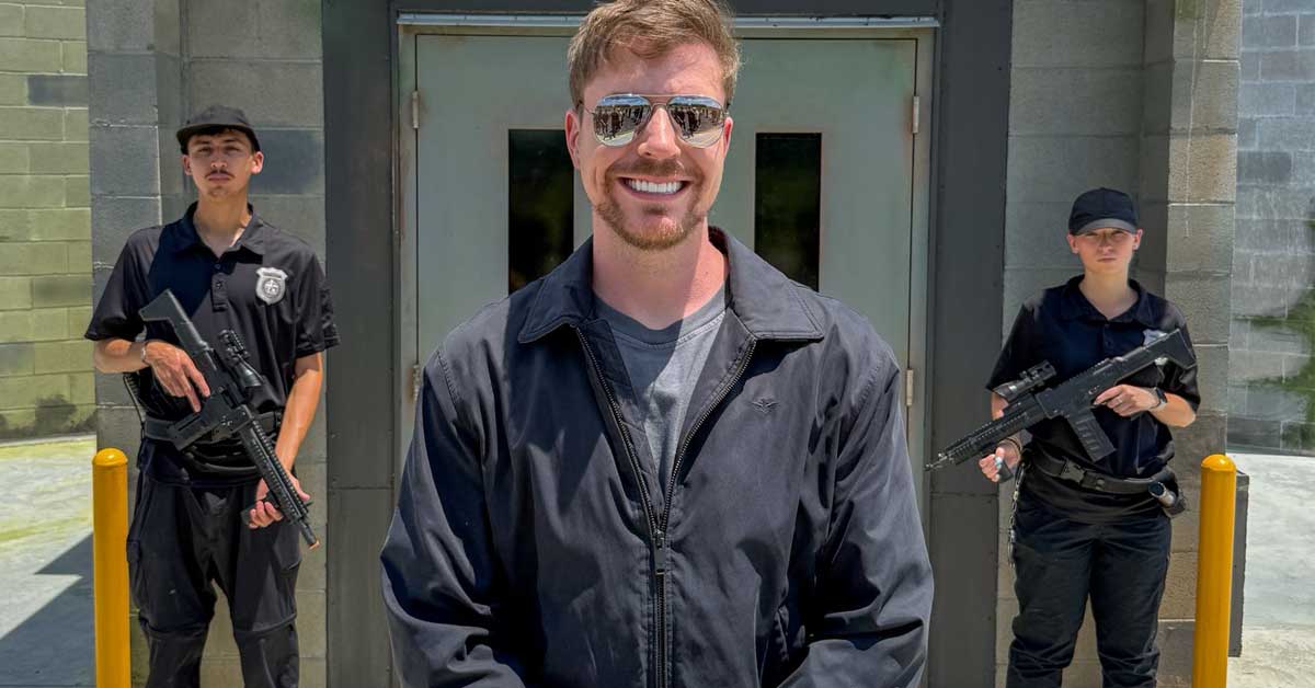 MrBeast standing in front of a prison set built for his $500,000 cop vs criminal challenge.