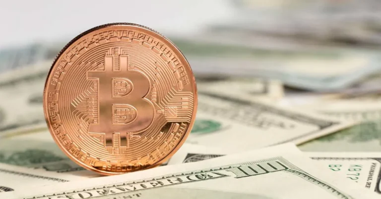 A picture of metallic bitcoin on dollar bills