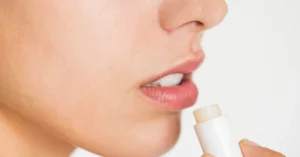Woman gently applying lip balm during her daily skincare routine