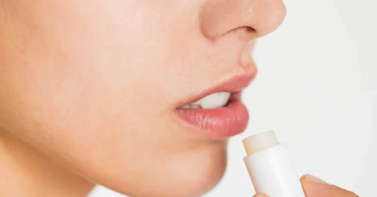 Woman gently applying lip balm during her daily skincare routine