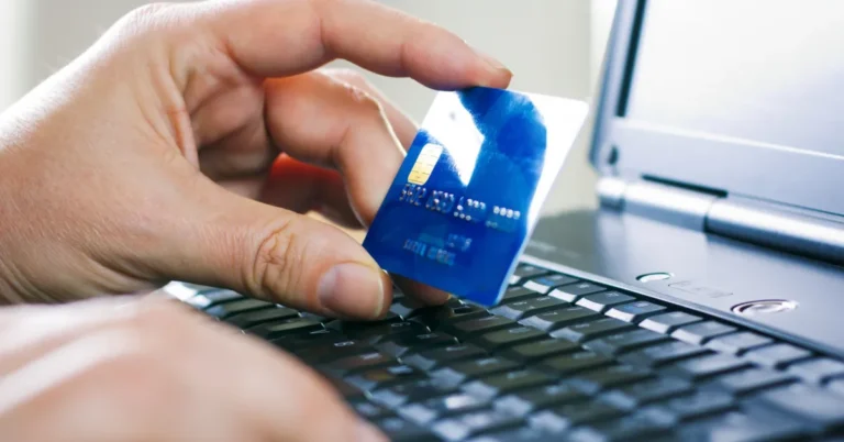 A person making an online payment using a credit card on a laptop device