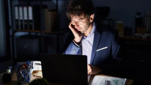 Tired startup founder working alone at night during first year business struggles