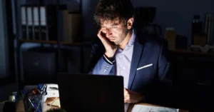 Tired startup founder working alone at night during first year business struggles