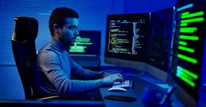 Indian developer staring at a computer screen as AI replaces developers thinking and coding tasks