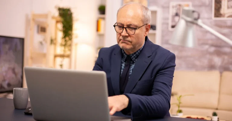 Mid-career professional reviewing resume on laptop while searching for jobs after a layoff.