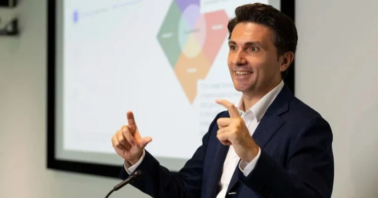 Roberto Croci speaking at a conference, discussing startup culture and work-life balance, captured from his X (Twitter) profile.