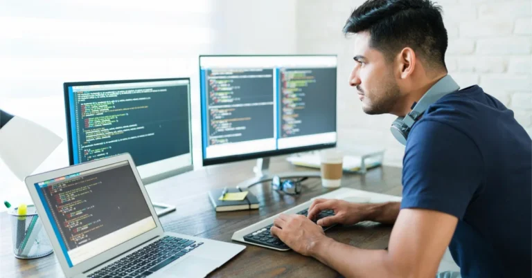 A software developer working from home on a laptop, building a startup after being laid off from a tech job