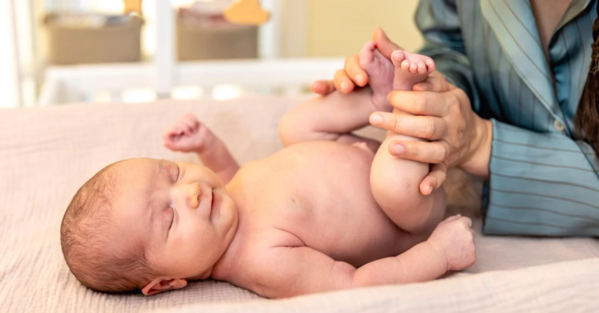 A newborn care specialist gently supports a baby during overnight care at home.