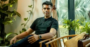 Varun Gupta, co-founder and CEO of GoBoult, seated in a relaxed indoor setting with green plants in the background