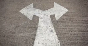 Road sign showing an arrow splitting into two directions, symbolizing the choice between paths in entrepreneurship