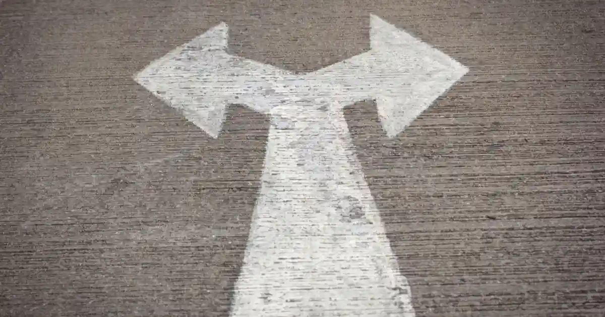 Road sign showing an arrow splitting into two directions, symbolizing the choice between paths in entrepreneurship