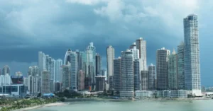 Skyline of tall commercial and residential buildings in a modern city at dusk, representing smart buildings equipped with AI-powered security systems