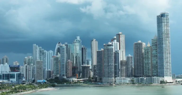 Skyline of tall commercial and residential buildings in a modern city at dusk, representing smart buildings equipped with AI-powered security systems