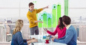 A man presenting an upward growth chart with percentage markers to three colleagues at an office table overlooking a city skyline