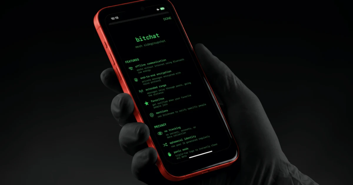Black-gloved hand holding a red iPhone that shows the Bitchat app's green-on-black feature screen, with offline communication, end-to-end encryption and a no-tracking privacy section listed